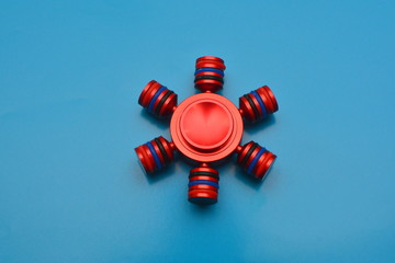 Red hand spinner. Fidget toy for increased focus, stress relief in an isolated red background