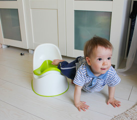 A little boy learns to go potty. Accustom the child to the potty..