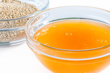 Quinoa and honey in a glass bowl isolated on white background. Closeup shot. Healthy food concept.