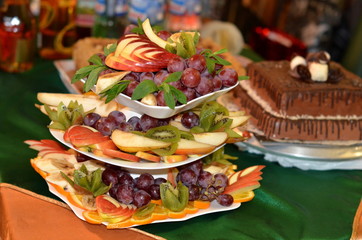 
Three dishes are tiers and filled with fruit, cut figuratively.