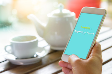 Morning coffee with e-news on smartphone in hand