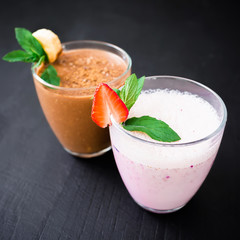 Blueberry smoothie with strawberry and banana smoothie on dark wood background. Fresh milkshake
