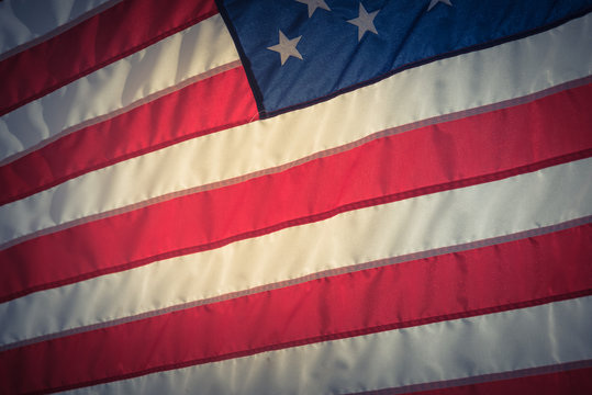 Close-up American Flag Flowing, Waving Star And Striped American Flag. Ruffled USA Flag. Flag Of The USA Blowing Wind. Vintage Tone.