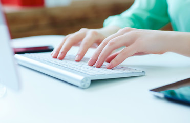 Female office worker typing on the keyboard.