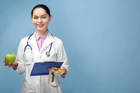 Portrait of young female nutritionist on light background