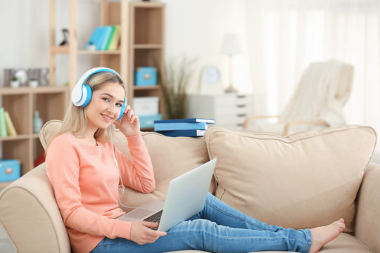 Young woman listening to audio book at home