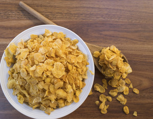 Corn flakes and bowl on wood table focus selective corn flakes on bowl
