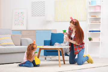 Little girl and her mother playing while cleaning up at home