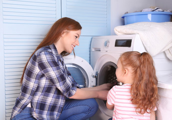 Daughter and mother doing laundry at home