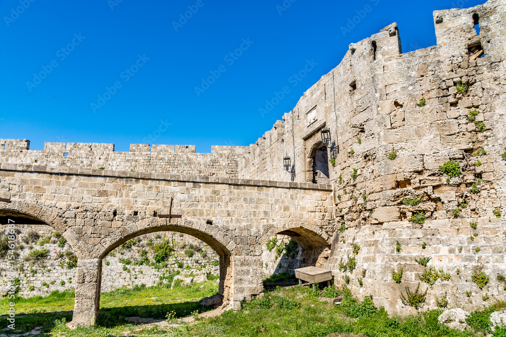 Wall mural gate of saint john, bridge leading to it and moat at rhodes old town, rhodes island, greece