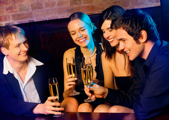 Young happy people with champagne at party