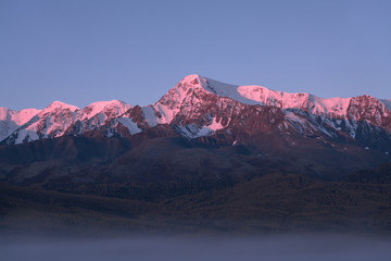 Fototapeta na wymiar Tops of mountains sparkling by rising sun
