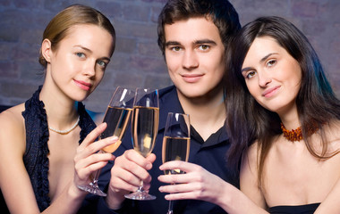 Young happy people with champagne at party