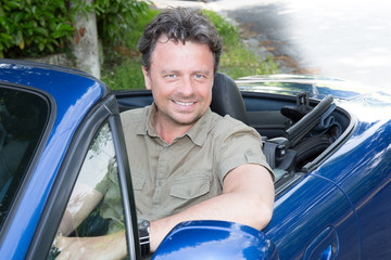 Fototapeta na wymiar middle-aged man driving his blue car