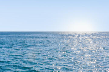 Blue calm deep sea with sunlight reflected on it