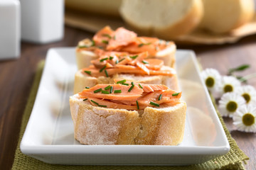 Brot mit Räucherlachs und Schnittlauch, fotografiert mit natürlichem Licht (Selektiver Fokus, Fokus auf den vorderen Lachs)