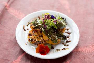 Fritters with Vegetable Topping with Orange Sauce on Round Plate