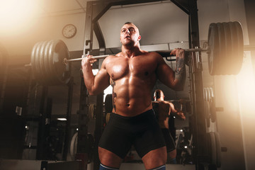 Weightlifter exercise with barbell in sport gym