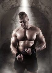Fototapeta na wymiar Muscular male athlete posing in gym