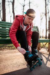 Roller skater sitting on bench and lace up skates