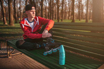 Roller skater posing on the bench in skates