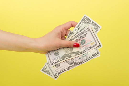 Fifty, Five And One Dollars In The Woman's Hand, Yellow Background