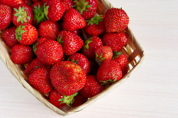 Basket of fresh strawberries on a wooden table