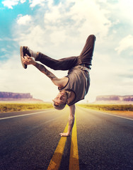 Young male hip hop dancer posing on a road