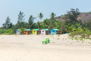 Palolym beach, colorful bungalows on the sea on the background of coconut palms, Goa, India.