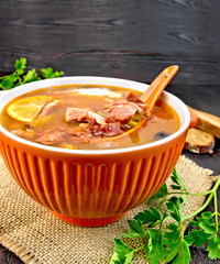 Solyanka with spoon in bowl on sackcloth