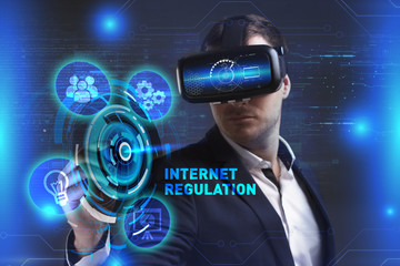 Business, Technology, Internet and network concept. Young businessman working in virtual reality glasses sees the inscription: Internet regulation