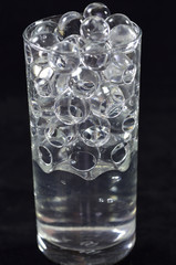 Silicone balls in a glass with water on a black background