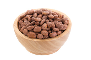 pinto beans  in a wooden bowl isolated on a white background.