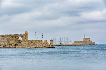 Walls of the Rhodes old town and Agios Nikolaos fort on a cloudy day, Rhodes island, Greece