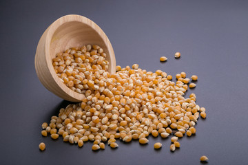 Corn in a wooden bowl on a black background
