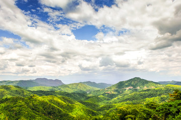 Obraz premium Beautiful mountain landscape, with mountain peaks covered with forest and a cloudy sky