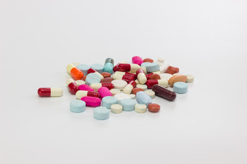 Multicolor antibiotics tablets and capsules on white background.