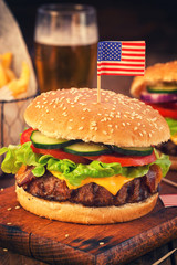 American Burger with bacon,cheese,tomato,lettuce and french fries at a Picnic for 4th of July 