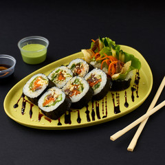 Gimbap. Korean Seaweed and Rice Rolls served on green plate with wasabi and soy sauce and chopsticks.