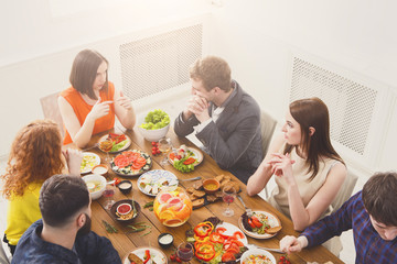 Group of happy people at festive table dinner party