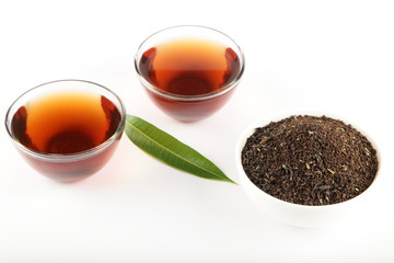 Fresh tea cups with heap of leaf tea dust
