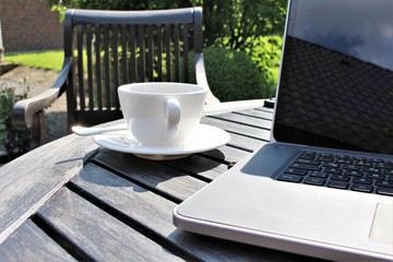 An image of a coffee with laptop in the sun
