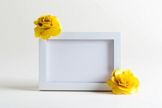 Blank white picture frame with flowers