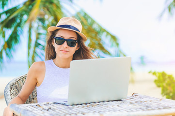 Young woman working in laptop on the beach. Freelance work