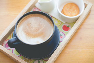 hot coffee with foam milk art in afternoon break(selective focus, vintage effect)