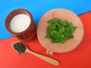 Milk with fresh mint and dried mint with red and blue background