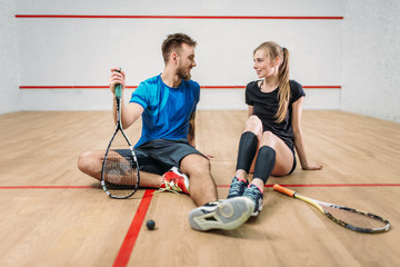 Squash game concept, young couple, rackets, ball