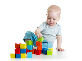 Lovely toddler baby playing with building cubes. Isolated on white.
