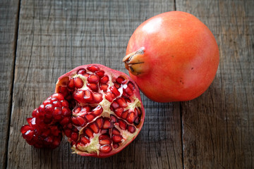 Ripe pomegranate fruit on wooden vintage background.