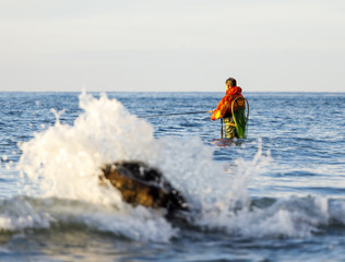 Angler in Wathose steht im Wasser - Ostsee